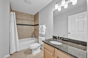 a bathroom with a sink and a toilet and a bath tub at Central Downtown Condo | Parking & Pool Table in Cleveland +21 photos