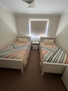 two beds sitting next to each other in a room at 367 The Avenue in Harvey