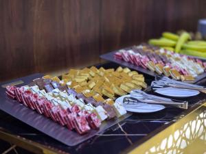 a table topped with different types of food and snacks at Midhal Al Ezz Ajyad Hotelفندق مدهال العز in Mecca