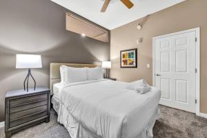 a bedroom with a large white bed and a lamp at Luxe Downtown Condo • Pool Table & Parking in Cleveland