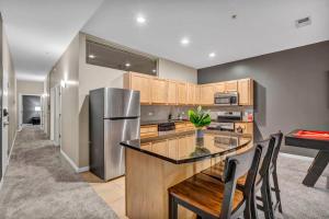 a kitchen with a table and a stainless steel refrigerator at Luxe Downtown Condo • Pool Table & Parking in Cleveland