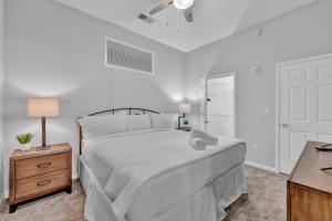 a white bedroom with a bed and a table at Theater District Gem • Downtown Hideaway in Cleveland
