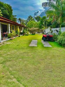 a yard with a tractor parked in front of a house at Brito Hospedagem in Barreirinhas