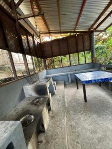 a room with benches and a table in a building at Gratum Beach 1 & 2 Resorts Glamping in Dapitan