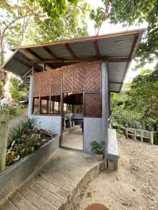 a building with awning and a bench in a garden at Gratum Beach 1 & 2 Resorts Glamping in Dapitan