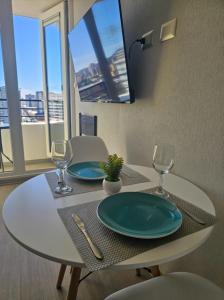 a table with two plates and wine glasses on it at Modern fully equipped studio with parking in Concepción