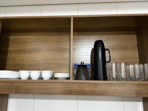 a cupboard with a coffee maker and dishes on it at Vila Estrela in Ponta Grossa