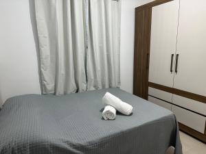 a bedroom with a bed with two towels on it at Vila Estrela in Ponta Grossa