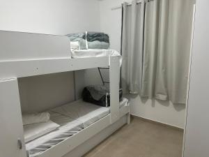 a white bunk room with two bunk beds at Vila Estrela in Ponta Grossa