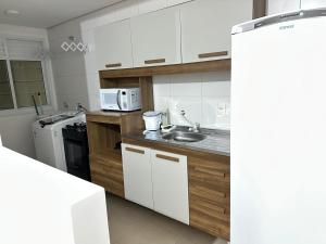 a kitchen with a sink and a microwave at Vila Estrela in Ponta Grossa