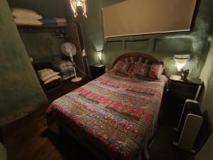 a bedroom with a bed with a colorful blanket at Odisea in Villa Serrana