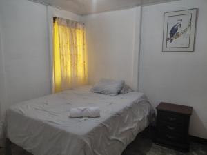a bedroom with a bed with two towels on it at Inmoexito Eco Tours in Upala
