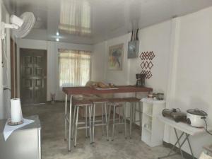 a kitchen with a table and stools in a room at Inmoexito Eco Tours in Upala +5 photos