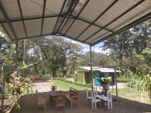 a patio with a table and chairs under a canopy at Inmoexito Eco Tours in Upala