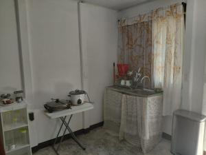 a kitchen with a table and a sink in a room at Inmoexito Eco Tours in Upala
