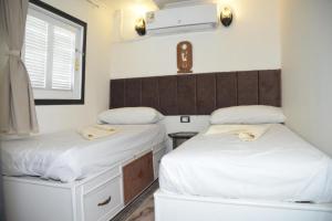 a room with two beds and a window at Cinderella dahabya in Luxor
