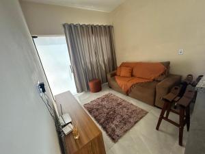 a living room with a couch and a bed at Casa, Delfinópolis - Serra da Canastra, MG in Delfinópolis