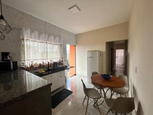 a kitchen with a table and chairs and a kitchen with a refrigerator at Casa, Delfinópolis - Serra da Canastra, MG in Delfinópolis
