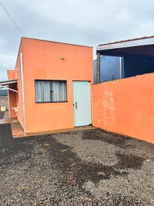 an orange building with a door in the side of it at Casa, Delfinópolis - Serra da Canastra, MG in Delfinópolis
