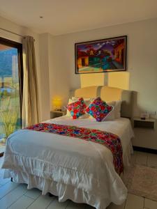 a bedroom with a large white bed with pillows at The Madevelyn in Atitlán in Panajachel