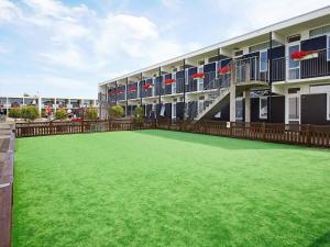 a large green lawn in front of a building at 4 person holiday home on holiday park in Glesborg in Glesborg