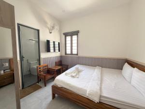 a bedroom with a large bed and a bathroom at Motel Nam Nguyên in Buôn Kô Sir