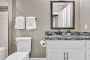 a bathroom with a toilet and a sink and a mirror at LUXE Condo Downtown | Security•Gym•Parking in Cleveland +21 photos