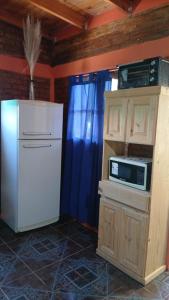 a kitchen with a white refrigerator and a microwave at Cabañas Arelí in Santa María