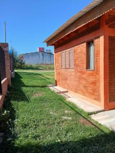 a house with a grass yard next to a building at Cabañas Arelí in Santa María