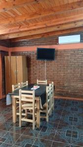 a dining room with a table and chairs and a tv at Cabañas Arelí in Santa María