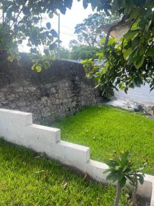 a stone wall with a staircase in the grass at Casa Perfectamente Ubicada in Tampico