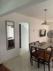 a dining room with a table and chairs and a mirror at Casa Perfectamente Ubicada in Tampico