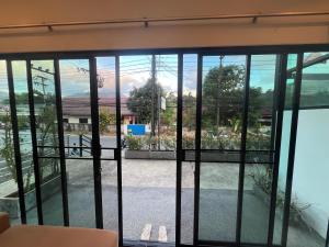 a view from the living room of a house through the sliding glass doors at Nern khao Guesthouse in Kamala Beach
