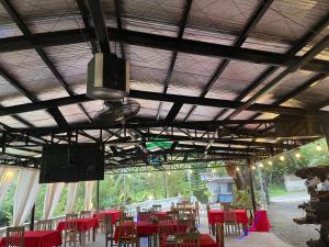 a dining room with red tables and chairs and a television at Meg's Resort in Andoon