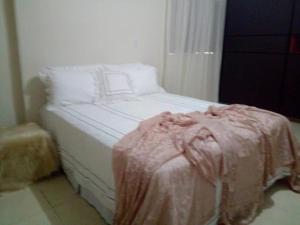 a white bed with a pink blanket on it at Rancho Nobre Produções TEMPORADA MOTO GP GOIÂNIA 5min, autódromo in Senador Canedo