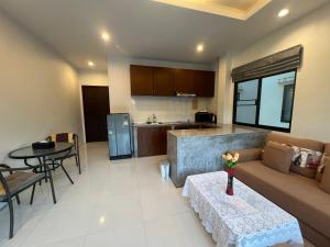 a living room with a couch and a table and a kitchen at Nern khao Guesthouse in Kamala Beach