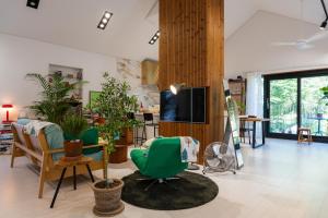 a living room with green chairs and a tv at 연봉리 스테이 in Hongcheon