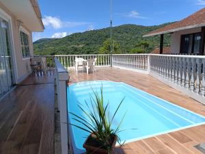 a swimming pool on the deck of a house at Hospedagem Doce Lar - Casa Manacá in Teresópolis