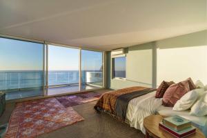 a bedroom with a bed and a large window at The Veranda - Panoramic Bay Views Private Beach Access Pool in Mount Eliza