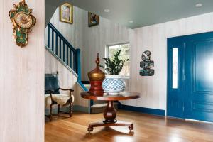 a room with a blue door and a table with a vase at The Veranda - Panoramic Bay Views Private Beach Access Pool in Mount Eliza +50 photos