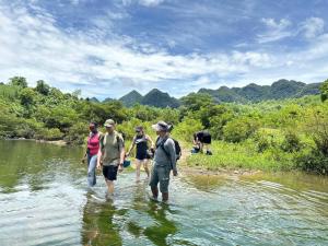 a group of people walking in the water at Linda Home in Phường Chày