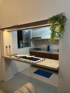 a kitchen with a counter with plates and utensils at Casas Temáticas in Tramandaí
