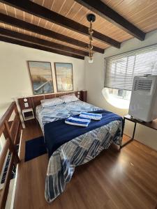 a bedroom with a bed with two towels on it at Casas Temáticas in Tramandaí
