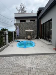 a backyard with a blue swimming pool in front of a house at Casas Temáticas in Tramandaí