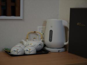 a counter with a blender and a group of tea cups at 大同GardenHotel 大阪西九条Annex in Osaka +16 photos