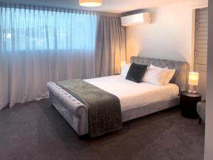 a bedroom with a large bed and a window at Navigate Seaside Hotel in Napier