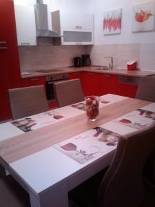 une cuisine avec une table en bois et des placards rouges dans l'établissement Apartments Villa Lavanda, à Zadar