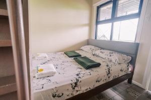 a small bed in a room with a window at Serenity Busay Room 6 in Cebu City