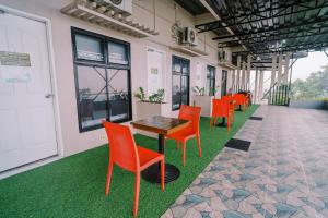 a row of orange chairs and a table in a building at Serenity Busay Room 6 in Cebu City