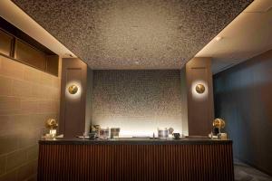 a bathroom with a counter in a room with lights at GRIDS PREMIUM HOTEL OSAKA NAMBA in Osaka